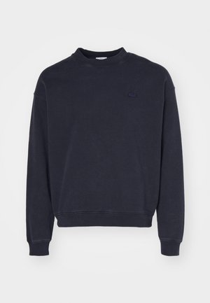 Felpa blu navy con colletto rotondo, maniche lunghe, polsini a costine, tessuto texture e un piccolo logo tonale sul petto.