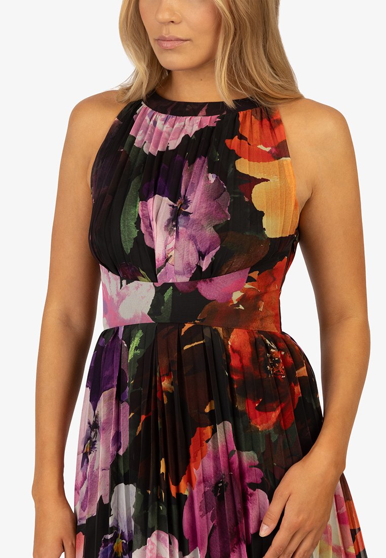Vestido plisado de tela oscura con vibrantes patrones florales en tonos morados, naranjas y rojos; diseño sin mangas con un escote alto.