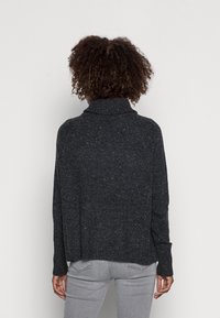 Dunkelgrauer Hoodie mit texturierter Oberfläche. Bietet einen lockeren Schnitt, lange Ärmel und einen gerippten Saum. Dezente Punkte im Material verleihen zusätzliche Details.