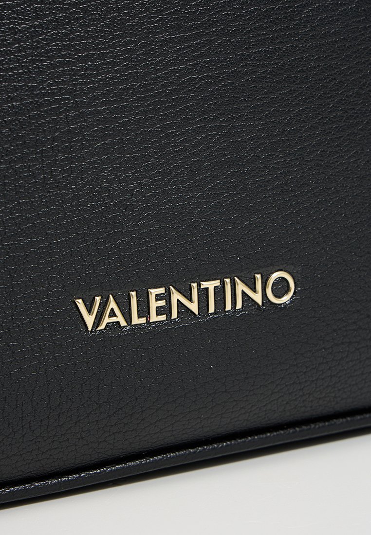 Sac en cuir noir avec une surface texturée et un logo doré "VALENTINO" affiché de manière proéminente à l'avant.