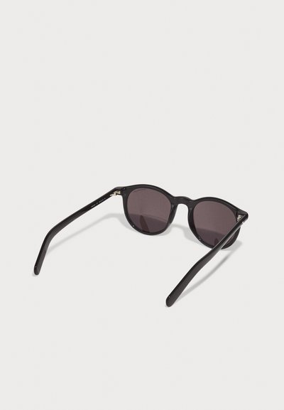 Black cat-eye sunglasses with dark tinted lenses, smooth textured plastic frame, and slim sleek arms. Notable hardware at the hinges.