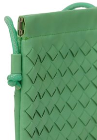 Grön läderclutch med ett vävt diamantmönster. Har en slät yta och ett ögla-handtag, säkrat med silverfärgad hårdvara på toppen.