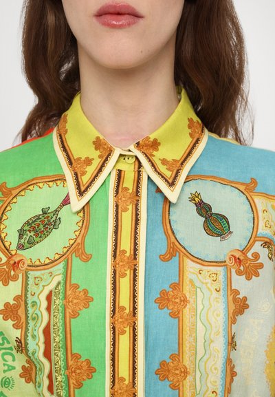 Colorful blouse featuring a green and blue design with gold accents, detailed embroidery of fish and vase motifs, and a yellow collar.