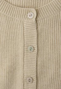 Beiger, gerippter Cardigan mit rundem Ausschnitt, der vier hellfarbige Knöpfe auf der Vorderseite zum Schließen aufweist und eine weiche Textur hat.
