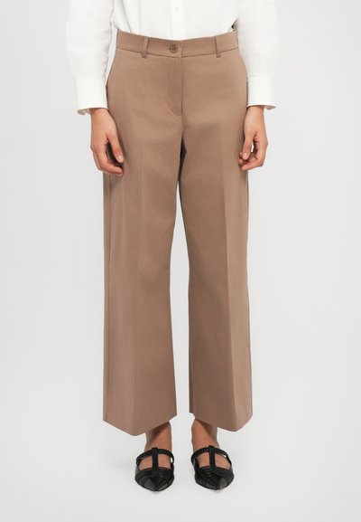 Pantalons larges, marron, en tissu léger ; dotés d'une fermeture à bouton, de poches avant et d'un pli le long des jambes.