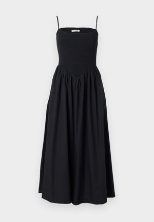 Black midi dress with thin straps, smocked bodice, and a flowing skirt. Made from lightweight fabric with a smooth texture.
