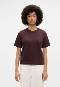 Bordo kokvilnas t-krekls ar īsām piedurknēm un klasisku apaļu kakla izgriezumu, ar brīvu piegriezumu un gludu tekstūru. Vienkāršs dizains, bez rakstiem vai akcentiem.