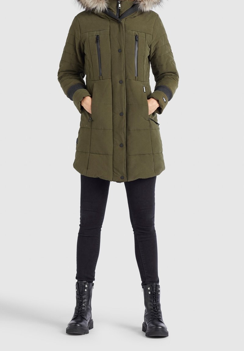 Olivgrön vadderad parka med huva kantad av päls, två dragkedjefickor på bröstet och sidfickor. Svarta accenter och ribbade cuffar.