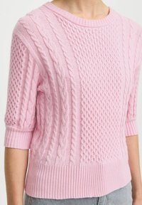 Hellrosa gestrickter Pullover mit einem Zopf- und Strukturmuster, kurzen Ärmeln und einem gerippten Saum für eine taillierte Passform.