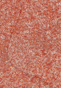 Tessuto a maglia di un vivace arancio con texture variegate; presenta un motivo stratificato con fili bianchi intrecciati che creano profondità e dimensione.