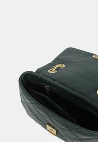 Borsa a tracolla nera trapuntata realizzata in materiale sintetico, con accessori in tonalità dorata, un'accents in catena e una tasca interna con zip.