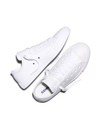 Coppia di sneakers Converse bianche basse con lacci su sfondo bianco, una scarpa leggermente inclinata che mostra viste laterale e superiore.