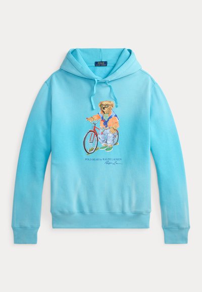 Sweat à capuche bleu clair avec un motif d'ours à vélo. Il est doté d'une capuche ajustable par cordon de serrage et de poignets et ourlet côtelés. Confectionné en tissu doux.