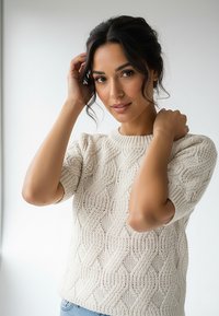 Jasnobeżowy sweter z dzianiny z teksturowanym wzorem warkocza, zaokrąglonym dekoltem i krótkimi rękawami. Miękka, gruba dzianina.