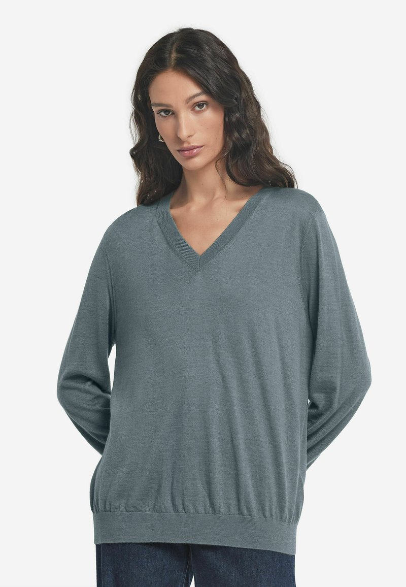 Sweter z dekoltem w serek, długim rękawem w stonowanym odcieniu niebieskiego, z prążkowanymi mankietami i dołem, w luźnym fasonie i gładkiej strukturze.