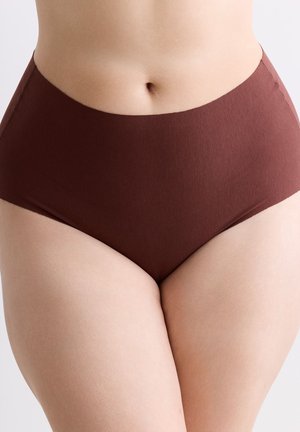 Nahaufnahme einer Person, die nahtlose, hoch taillierte braune Unterwäsche trägt, und dabei den unteren Torso und die oberen Oberschenkel zeigt.