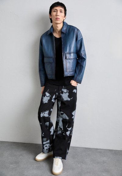 Kidsuper FACES COLLAGE PANTS - Traperice opuštenog kroja - black