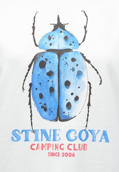 Balts T-krekls ar zila vabole grafiku un melniem plankumiem. Zemāk teksts "STINE GOYA CAMPING CLUB SINCE 2006" zila un sarkanā krāsā.