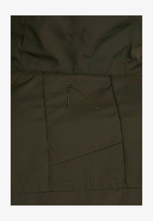 Ciemnooliwkowy materiał o gładkiej teksturze, z detalami przeszyć i małym, trójkątnym haftem na powierzchni.