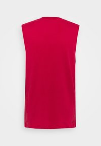 Débardeur de sport rouge sans manches vu de dos avec un tissu simple et lisse et un col rond.