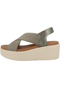 Grå lädersandal med korsade remmar, mjukt innertyg och en ljus färg på kilklacken. Har en slät yta och minimala detaljer.