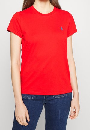 Czerwona bawełniana koszulka z okrągłym dekoltem, krótkimi rękawami i niebieskim haftowanym logo po lewej stronie klatki piersiowej. Gładka tekstura, klasyczny krój.