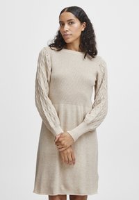 Strickkleid in hellbeige, mit geripptem Oberteil und strukturierten Zopfmusterärmeln, in lockerer Passform und Rundhalsausschnitt.