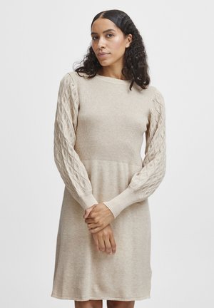 Strickkleid in hellbeige, mit geripptem Oberteil und strukturierten Zopfmusterärmeln, in lockerer Passform und Rundhalsausschnitt.