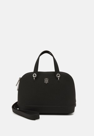 Czarna, skórzana torba w kształcie kopuły z dwoma górnymi uchwytami, odpinanym paskiem na ramię, srebrnym zamkiem błyskawicznym i małym, srebrnym logo marki z przodu.