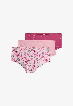 Kolme paria tyttöjen alushousuja vaaleanpunaisissa sävyissä. Yhdessä on juhlava kuosi, jossa on nauhoja ja holly-kasveja; muut ovat yksivärisiä vaaleanpunaisia ja tähdillä kuvioituja.