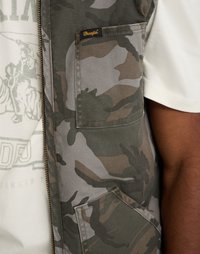 Roheline, halli ja pruuni tooni kamuflaažimustriga vest. Omab lukuga kinnitamist ja vasakul rinnal asuvat taskut, kus on kudumiga Wrangleri silt.