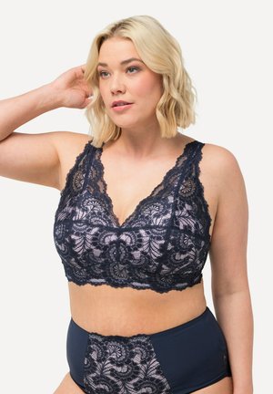 Marineblaues Spitzentop mit floralen Mustern, V-Ausschnitt, breiten Trägern und strukturiertem Finish. Kombiniert mit passenden hochgeschnittenen Slips.