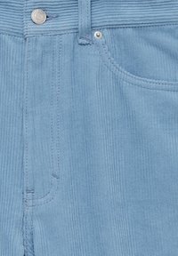 Tissu en velours côtelé bleu clair avec des côtes verticales, comprenant une poche avant et un détail bouton en métal. Texture lisse, couture visible.