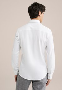 Witte longsleeve shirt met een rechte kraag, knoopmanchetten en een gladde stof. De achterkant heeft een yoke-detail en een afgeronde zoom.