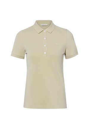 Polo beige à manches courtes avec col et quatre boutons blancs, avec petit logo "GANT" sur la poitrine gauche.