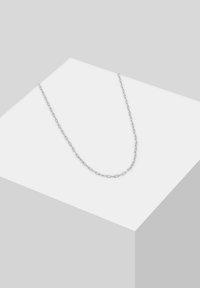 Zilveren ketting met verlengde schakels, een gladde textuur en een minimalistisch ontwerp, tentoongesteld op een monochrome ondergrond.