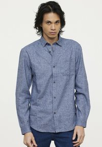 Blauwe, gestructureerde button-up shirt met een borstzak, lange mouwen en een standaard kraag. Voorzien van zwarte knopen en een relaxte fit.