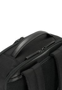 Zaino nero con materiale in nylon testurizzato, forma rettangolare, doppie chiusure con zip, manico imbottito e dettagli in rete.