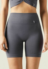 Höga mörkgrå träningsshorts gjorda av textil, stretchig material, med en slät midja och en åtsittande design.