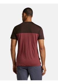Camiseta de manga corta con una parte superior de color marrón oscuro y una parte inferior de color burdeos. Textura suave, diseño de cuello redondo y acentos laterales.