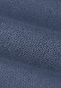 Gros plan d'un tissu tricoté bleu avec une texture visible et un fin motif de tissage en doux plis.