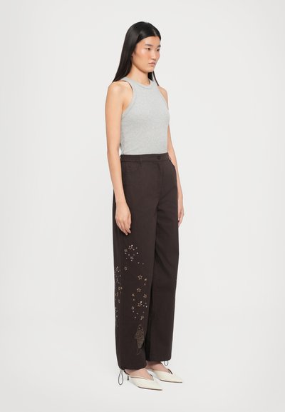 Gray sleeveless top paired with black wide-leg pants featuring colorful star and fish embroidery; soft fabric with a relaxed fit.