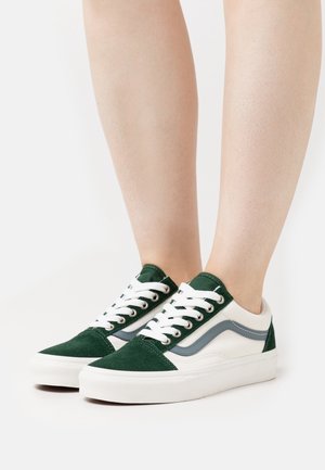 Grüne und weiße Sneaker aus Wildleder und Canvas-Materialien, klassisches Low-Top-Design, Schnürung mit fünf Ösen und dezente graue Akzente.