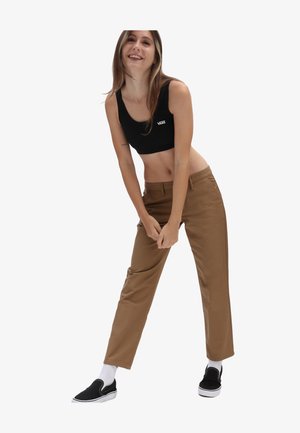 Černý cropped top, hnědé rovné kalhoty, bavlněný materiál, minimalistický design. Černé boty na klouzání s bílými podrážkami a ponožky do délky crew.