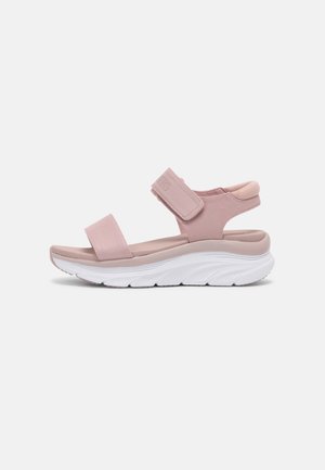 Sandal de color rosa con un upper texturizado, dos correas ajustables y una suela acolchada. Suela exterior blanca elegantes con un patrón de olas.