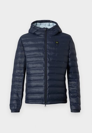 Donkerblauwe gewatteerde pufferjas met capuchon, ritssluiting aan de voorkant, elastische manchetten en een klein rechthoekig patch op de borst.