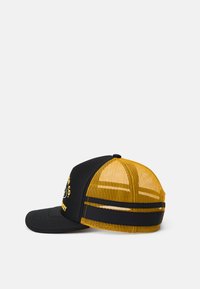 Black and yellow mesh trucker cap with curved brim, adjustable strap, and partial text on the front panel.