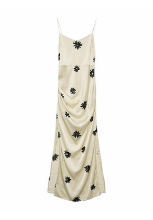 Satin haljina na slip u bež boji s crnim cvjetnim uzorcima. Ima tanke naramenice, drapirani dizajn i bočne proreze za lakše kretanje.