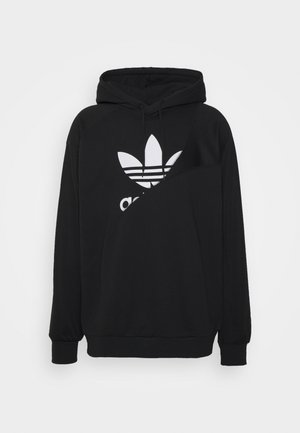 Sweat à capuche noir Adidas avec logo trefoil blanc partiellement recouvert par un panneau superposé asymétrique, avec une poche avant et une capuche à cordon.