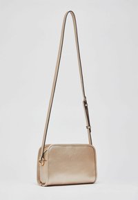 Bolso bandolera de cuero dorado con acabado texturizado, forma rectangular, correa ajustable y un pequeño detalle de herrajes metálicos.